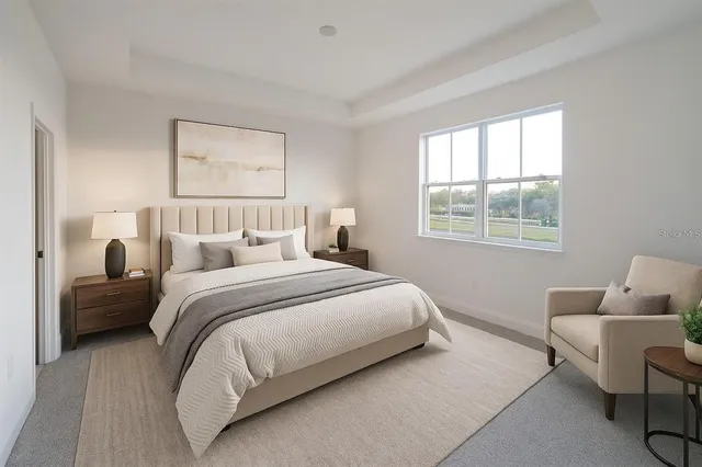 a bedroom with a bed a chair and a potted plant