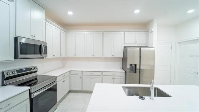 a kitchen with a sink stainless steel appliances and cabinets