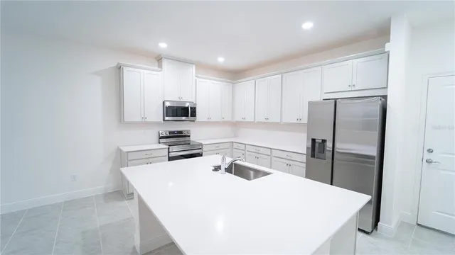 a kitchen with a refrigerator a stove top oven a sink and cabinets