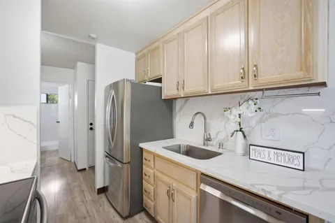 a kitchen with stainless steel appliances granite countertop a refrigerator sink and cabinets