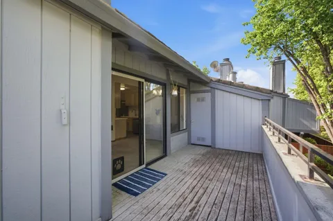 a view of a balcony with wooden floor and fence