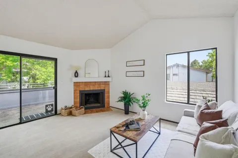 a living room with furniture a fireplace and a large window