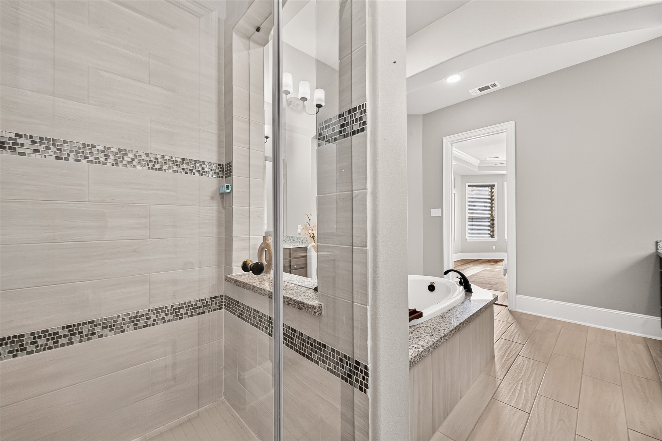 4207 Reagan Ridge Court Richmond, TX 77406 - Photo 35 of 50 Glass-enclosed shower and soaking tub create a relaxing owner’s bath.
