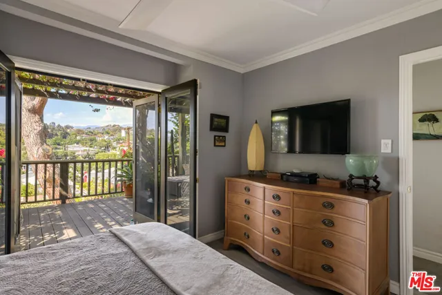 a bedroom with a bed and a flat tv screen on dresser