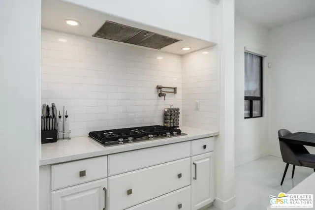 a kitchen with white cabinets and a stove