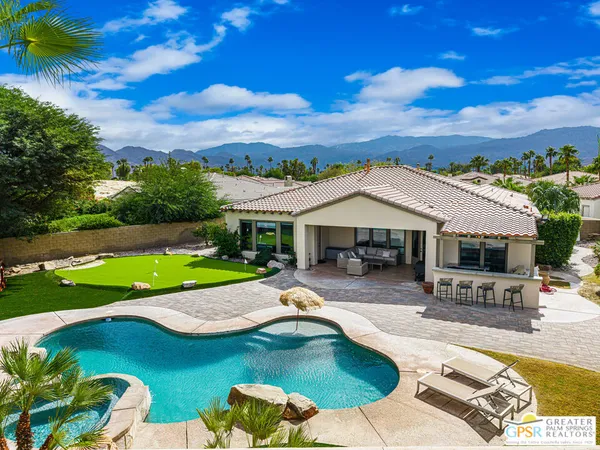 a view of a house with swimming pool and sitting area