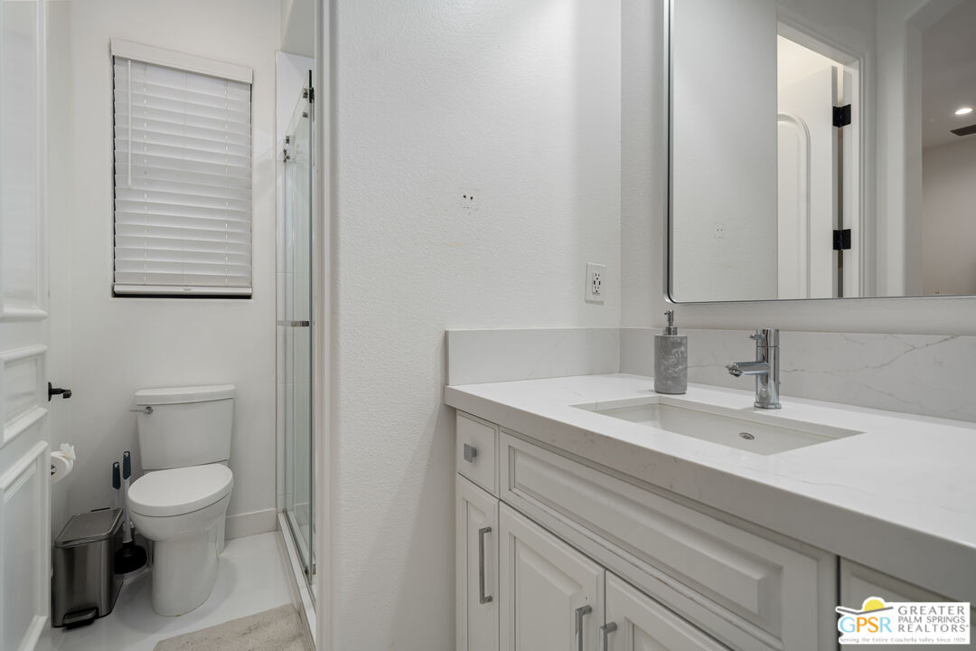 74226 Via Venezia Palm Desert, CA 92260 - Photo 25 of 38 a bathroom with a toilet a sink and a mirror
