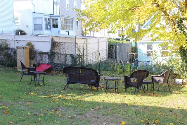 a backyard of a house with table and chairs