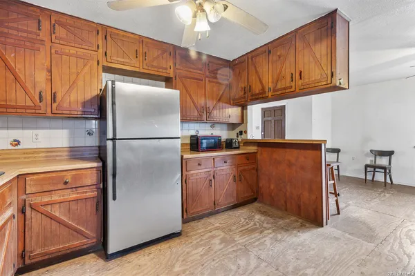 a kitchen with stainless steel appliances granite countertop a refrigerator a stove and a sink with cabinets