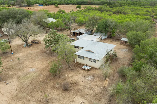 an aerial view of a house with yard and lake view