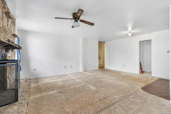 a view of a livingroom with a ceiling fan and entryway