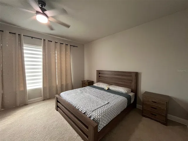 a bed sitting in a spacious bedroom next to a window