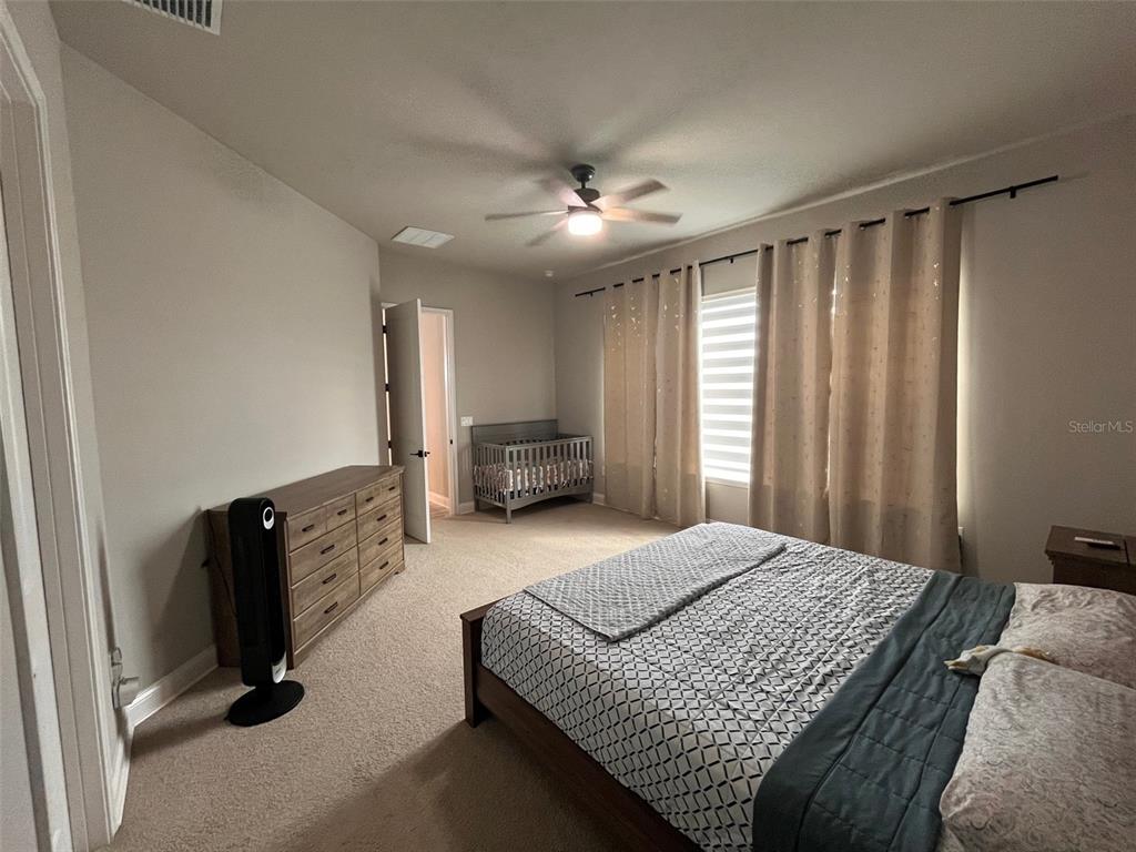 12149 Southwest 33rd Place Gainesville, FL 32608 - Photo 12 of 35 a bedroom with a large bed and dresser with mirror