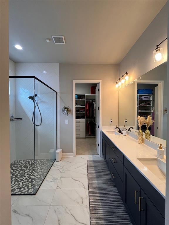 12149 Southwest 33rd Place Gainesville, FL 32608 - Photo 15 of 35 a large bathroom with a double vanity sink and a mirror
