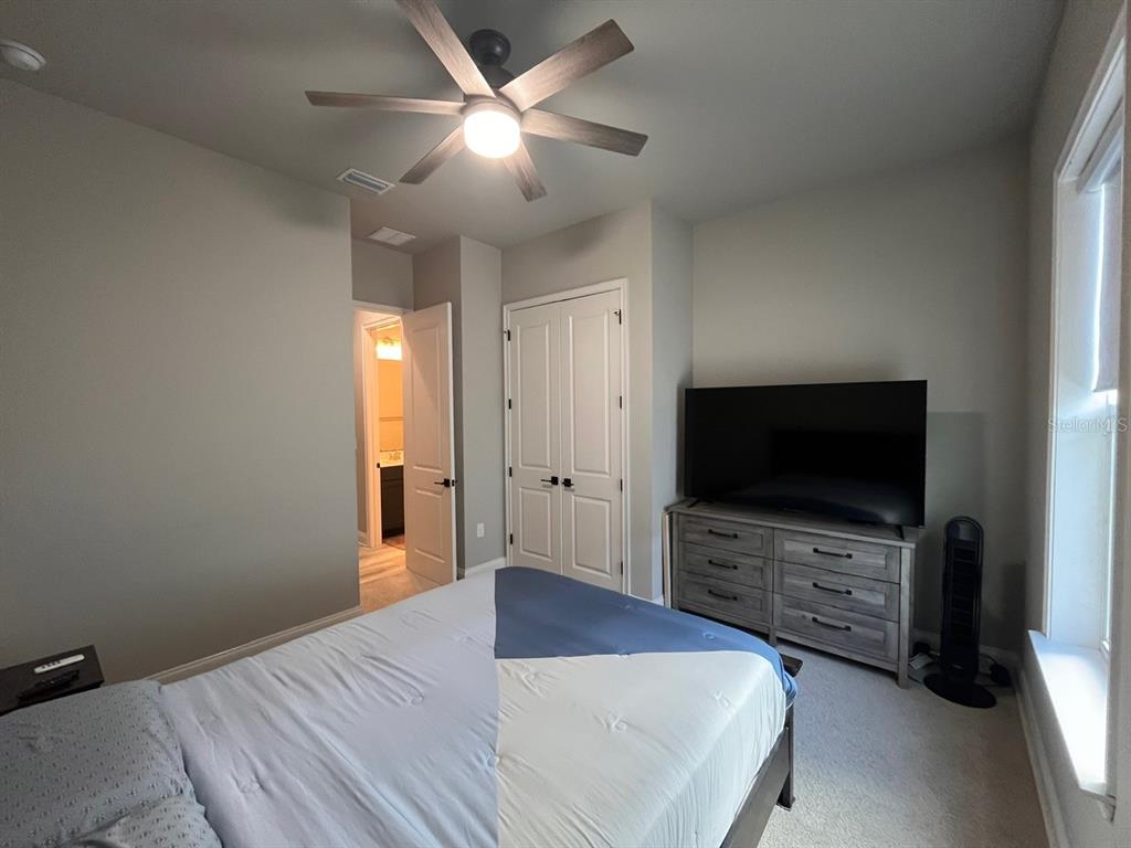 12149 Southwest 33rd Place Gainesville, FL 32608 - Photo 19 of 35 a bedroom with a bed and a flat screen tv