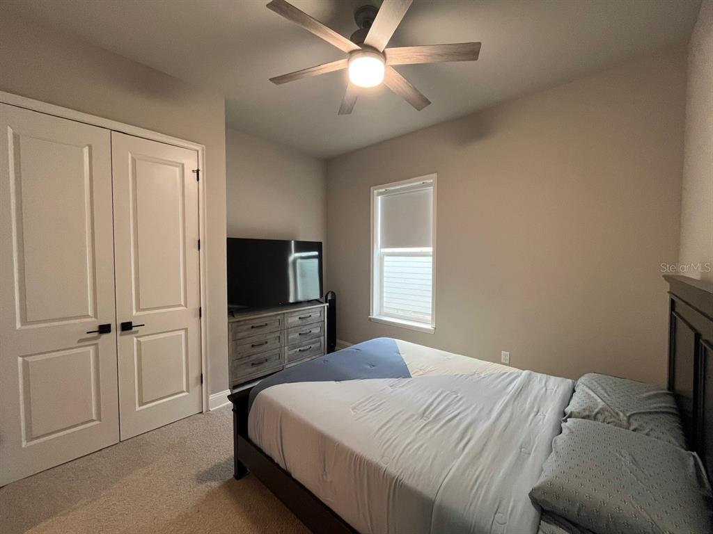 12149 Southwest 33rd Place Gainesville, FL 32608 - Photo 20 of 35 a bedroom with a bed and a flat tv screen on dresser