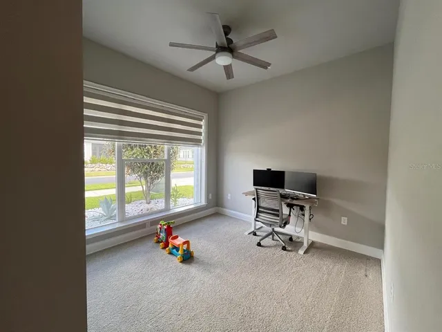 a view of a workspace with furniture and a window