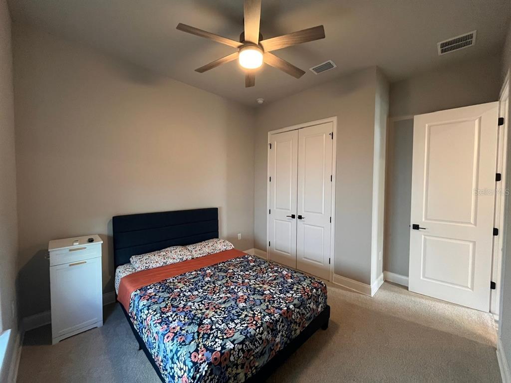 12149 Southwest 33rd Place Gainesville, FL 32608 - Photo 26 of 35 a bedroom with a bed and a ceiling fan