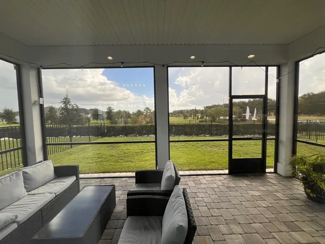 a living room with furniture and floor to ceiling windows