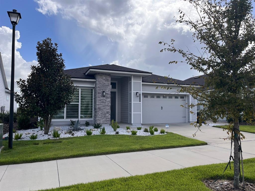 12149 Southwest 33rd Place Gainesville, FL 32608 - Photo 34 of 35 a front view of a house with a garden and trees