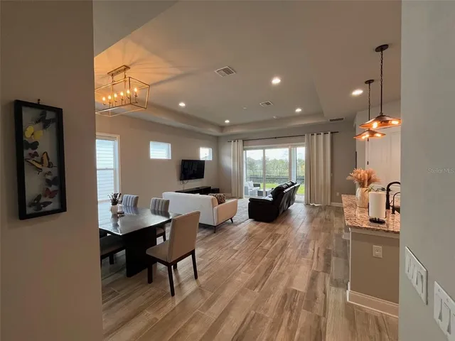 a living room with furniture a large window and wooden floor