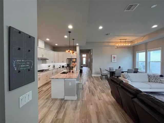 a large kitchen with stainless steel appliances lots of counter space and wooden floor