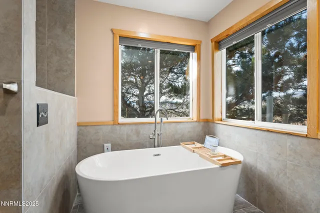 a white bath tub sitting in a bathroom next to a window