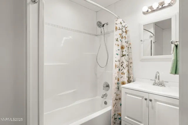 a bathroom with a sink a mirror a shower and a bathtub