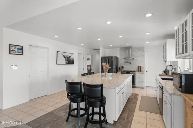a large white kitchen with stainless steel appliances lots of counter space and windows