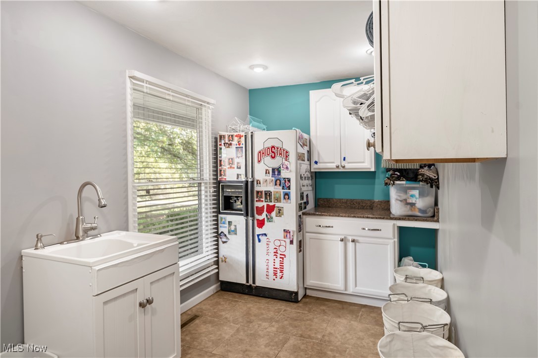 155 Ridgewood Boulevard Belpre, OH 45714 - Photo 28 of 49 Kitchen with white refrigerator with ice dispenser, white cabinets, light tile patterned floors, and dark stone counters