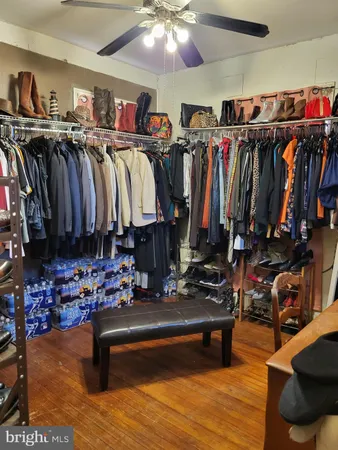 a walk in closet with clothes and shoes