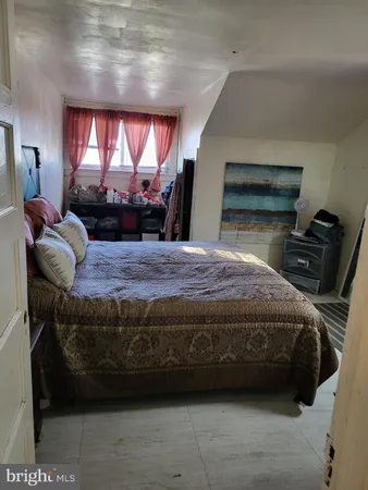 a bedroom with a bed window and dresser