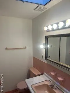 a bathroom with a toilet sink and mirror