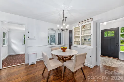 a dining room with furniture a chandelier and wooden floor