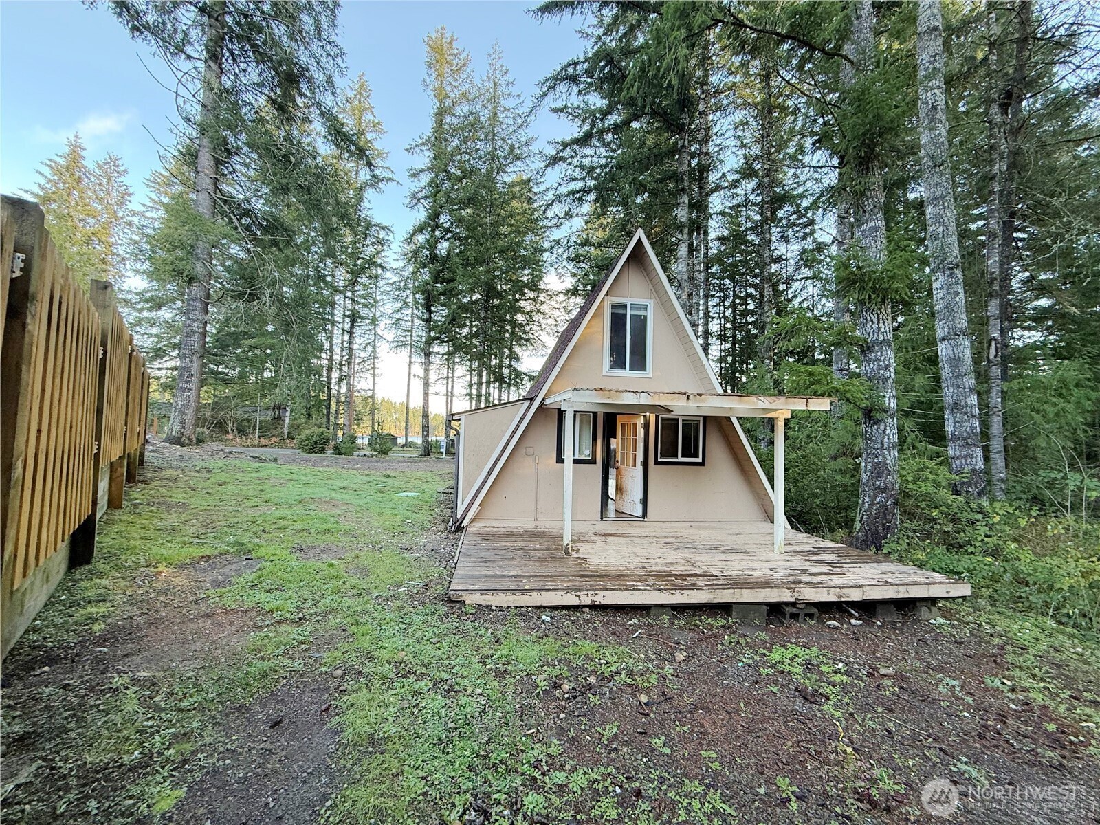 550 E Trail Belfair, WA 98528 - Photo 2 of 11 a view of a wooden house with a small yard and large trees