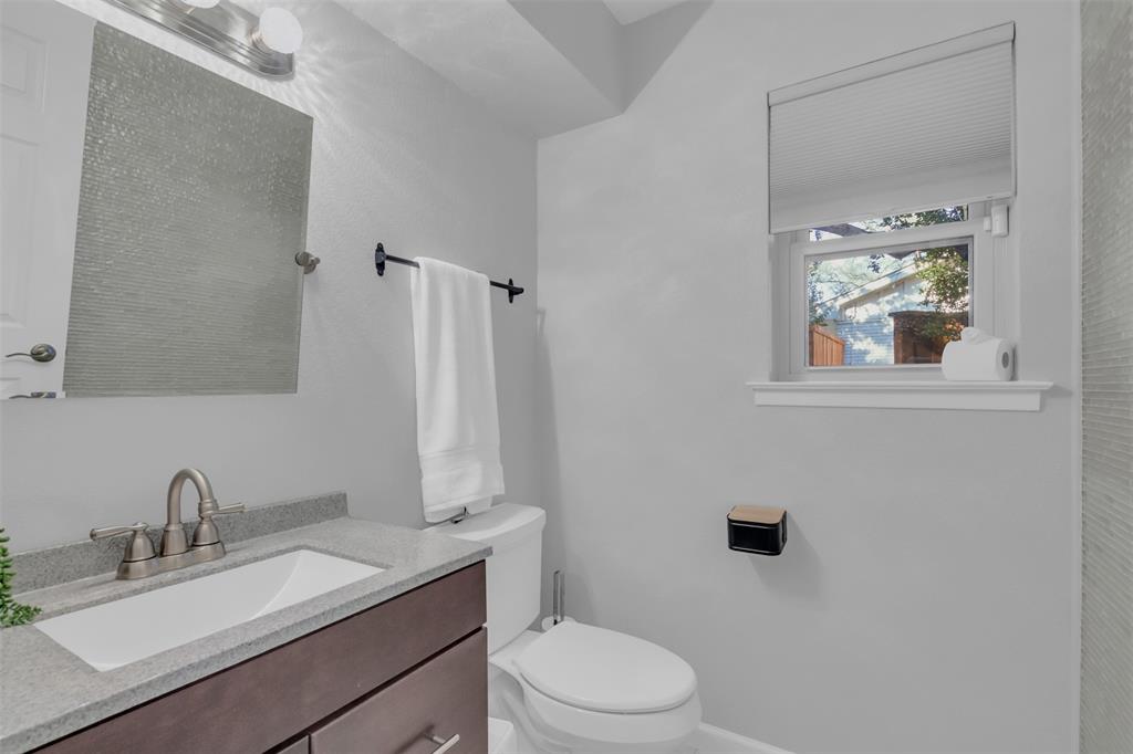4808 Thunder Road Dallas, TX 75244 - Photo 22 of 36 a bathroom with a granite countertop sink toilet a mirror and shower