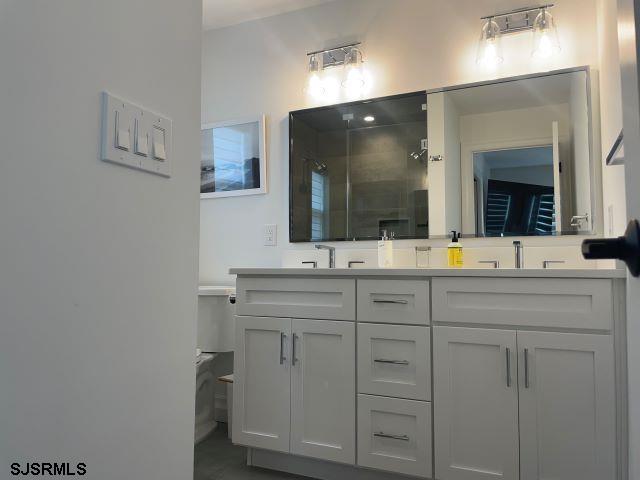 103 North Monroe Avenue, Unit MAY 15TH 2026JULY 31ST 2026 Margate City, NJ 08402 - Photo 20 of 33 a bathroom with a double vanity sink and mirror
