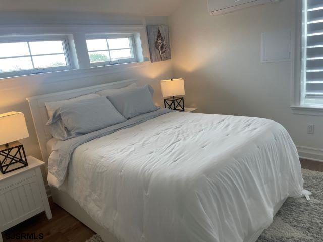 103 North Monroe Avenue, Unit MAY 15TH 2026JULY 31ST 2026 Margate City, NJ 08402 - Photo 26 of 33 a bedroom with a bed and window
