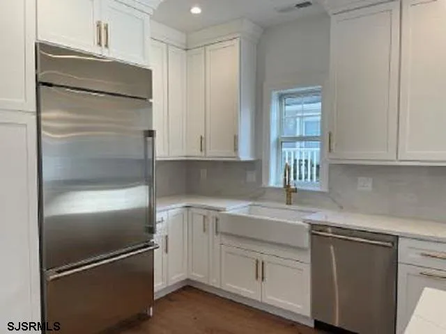 a kitchen with white cabinets and a refrigerator