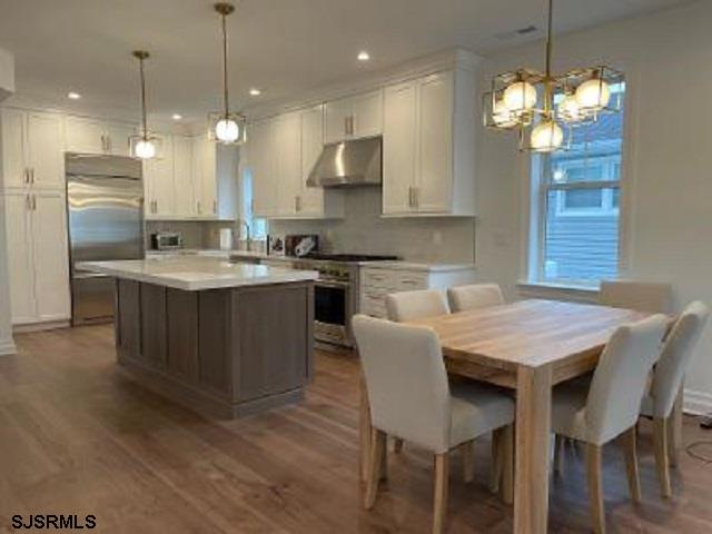 103 North Monroe Avenue, Unit MAY 15TH 2026JULY 31ST 2026 Margate City, NJ 08402 - Photo 8 of 33 a kitchen with a dining table a sink stainless steel appliances and cabinets