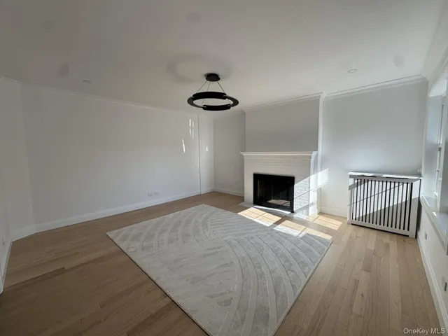 a view of empty room with wooden floor and fireplace