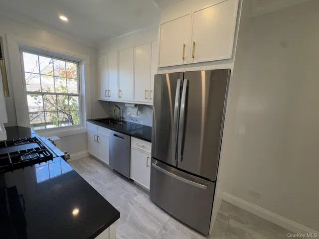 a kitchen with granite countertop a refrigerator and a sink
