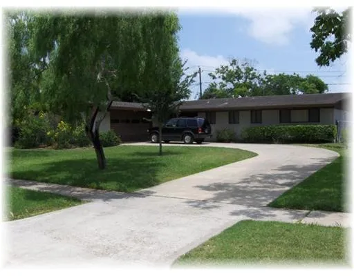 a view of a house with backyard and a garden