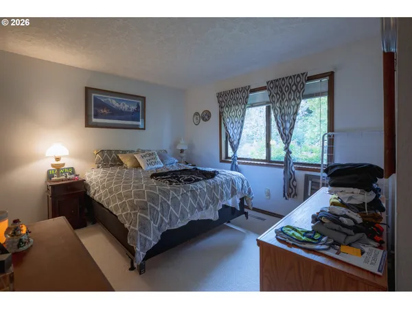a bedroom with a bed and a large window