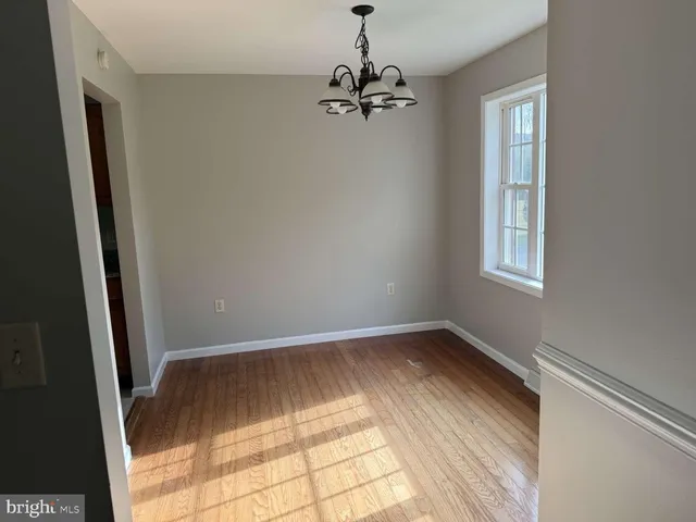 a view of a room with wooden floor and a window