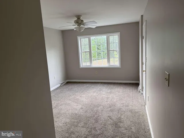 an empty room with windows and chandelier