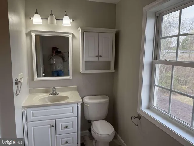 a bathroom with a toilet a sink and a window