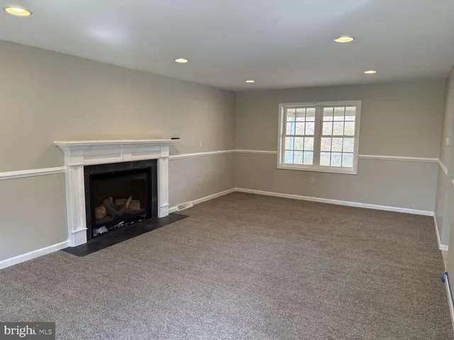 an empty room with a fireplace and window