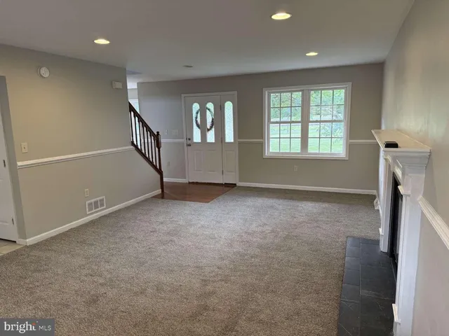 an empty room with windows and a fireplace
