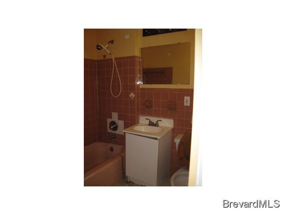 1119 Northeast Jordan Palm Bay, FL 32905 - Photo 10 of 12 a bathroom with a sink shower and a mirror